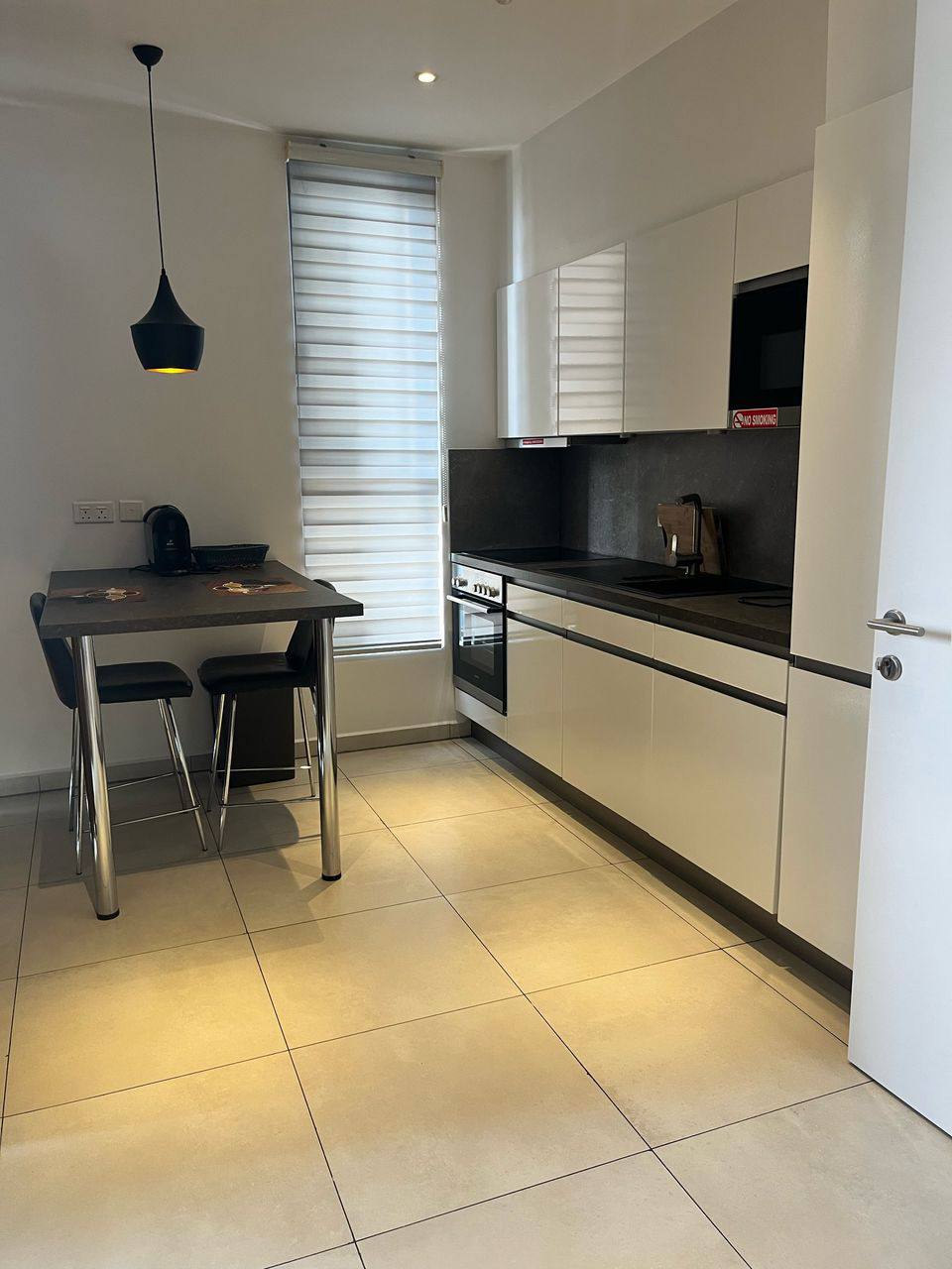 A kitchen with a white counter top and a white microwave